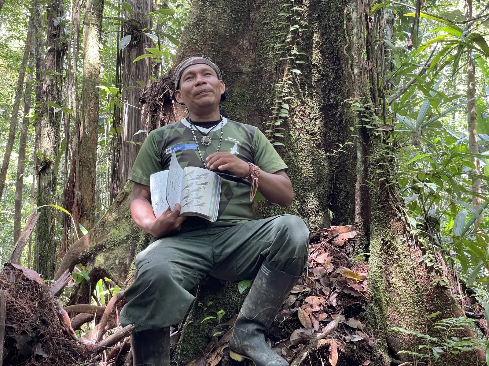 Sabedor indígena lee una guía en el bosque amazónico