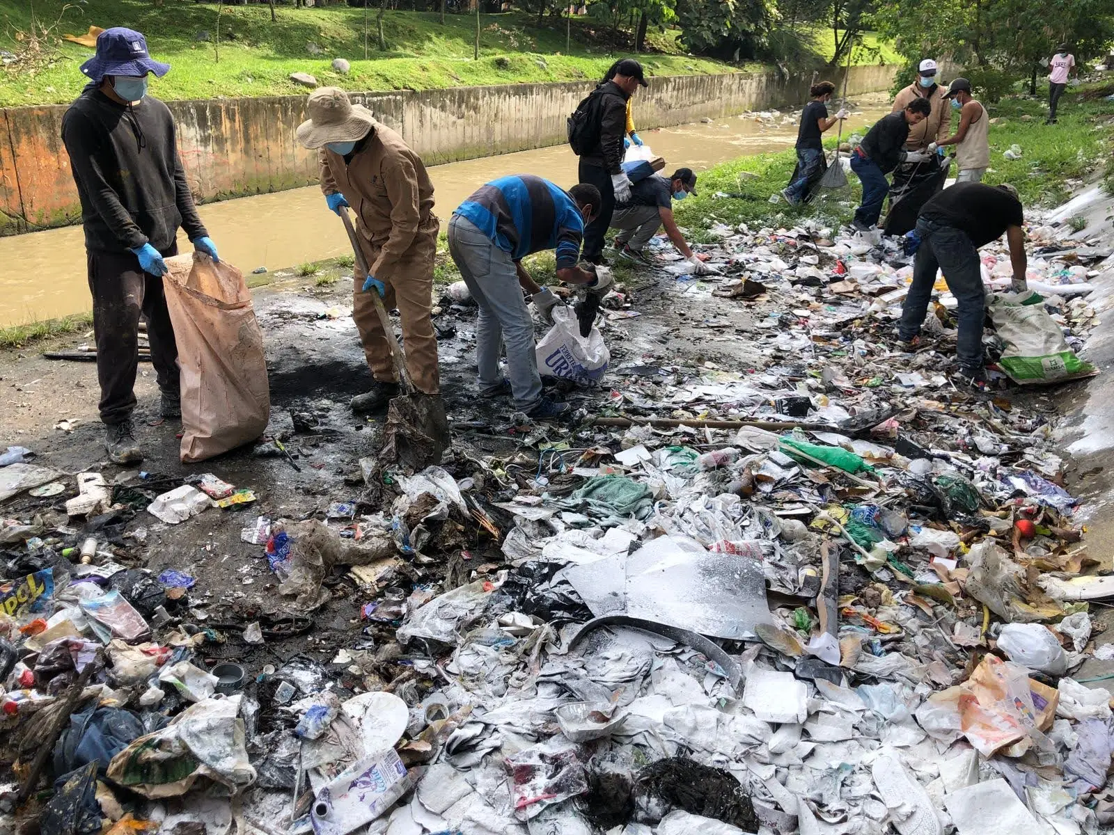 Voluntarios limpian residuos de un río